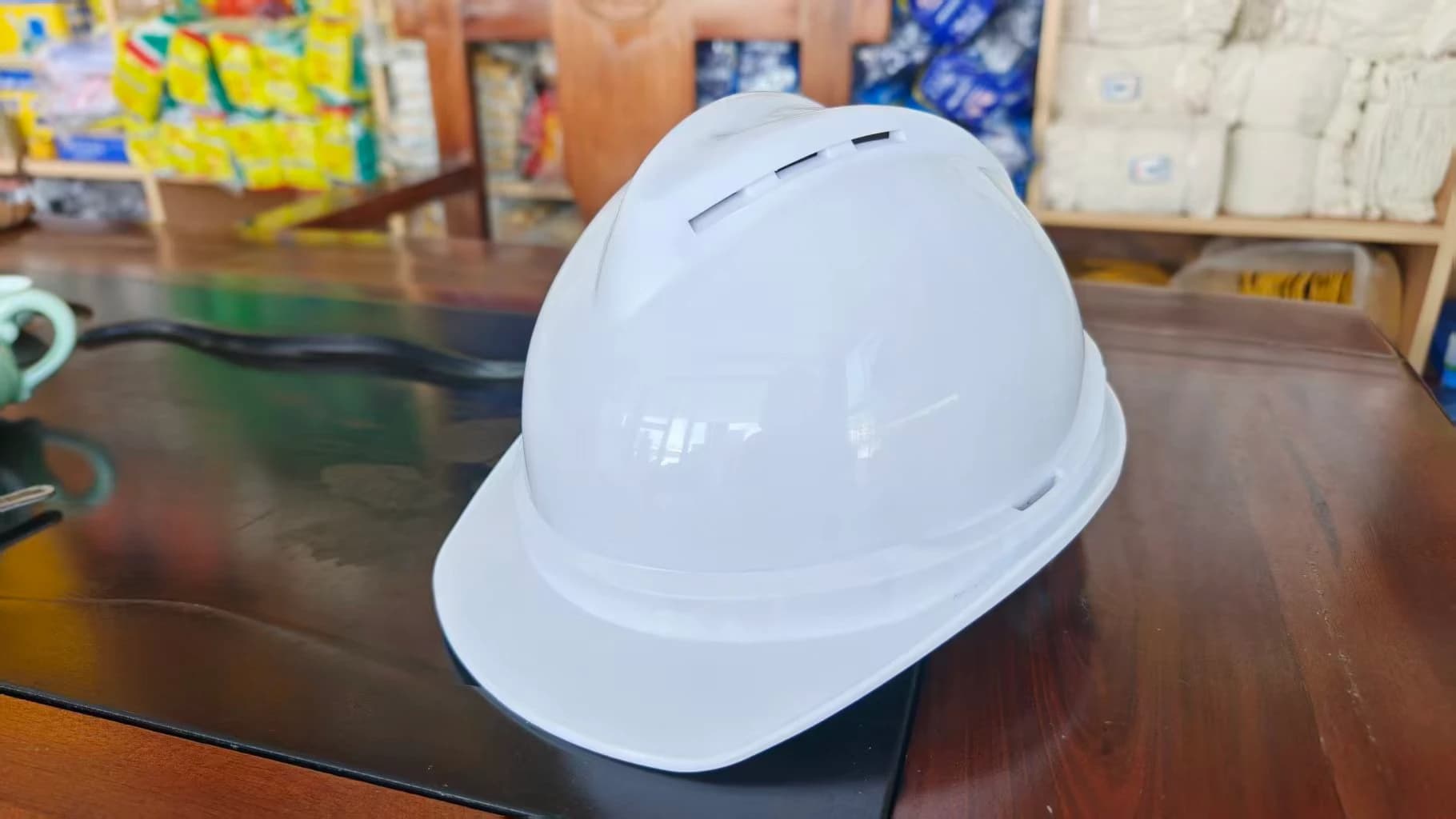 A white helmet sample with ventilation slots and a chin strap.