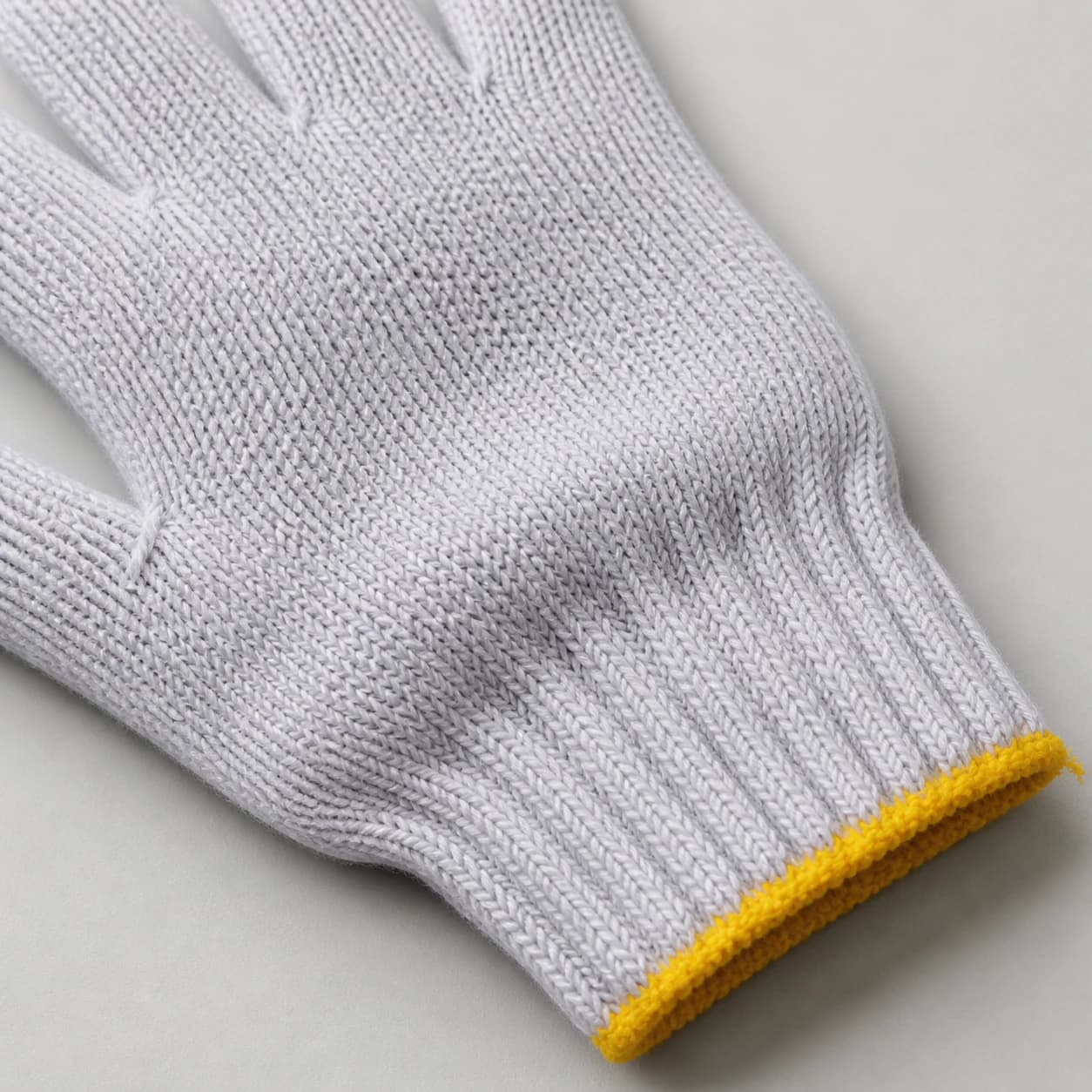 Close-up of bleached cotton glove knit and yellow cuff