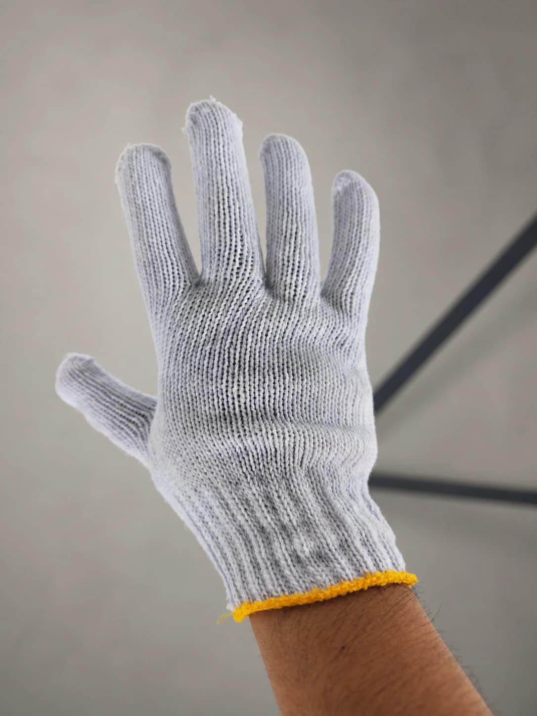 Bleached cotton string glove worn on hand, back view