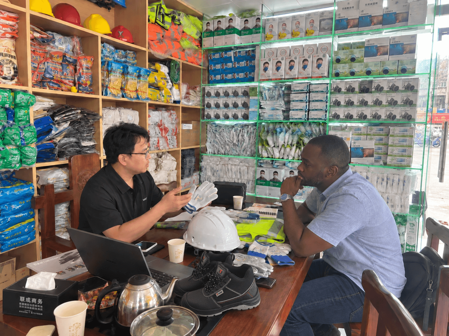 PPE sample discussion at the store, with gloves, a helmet and footwear on the table.