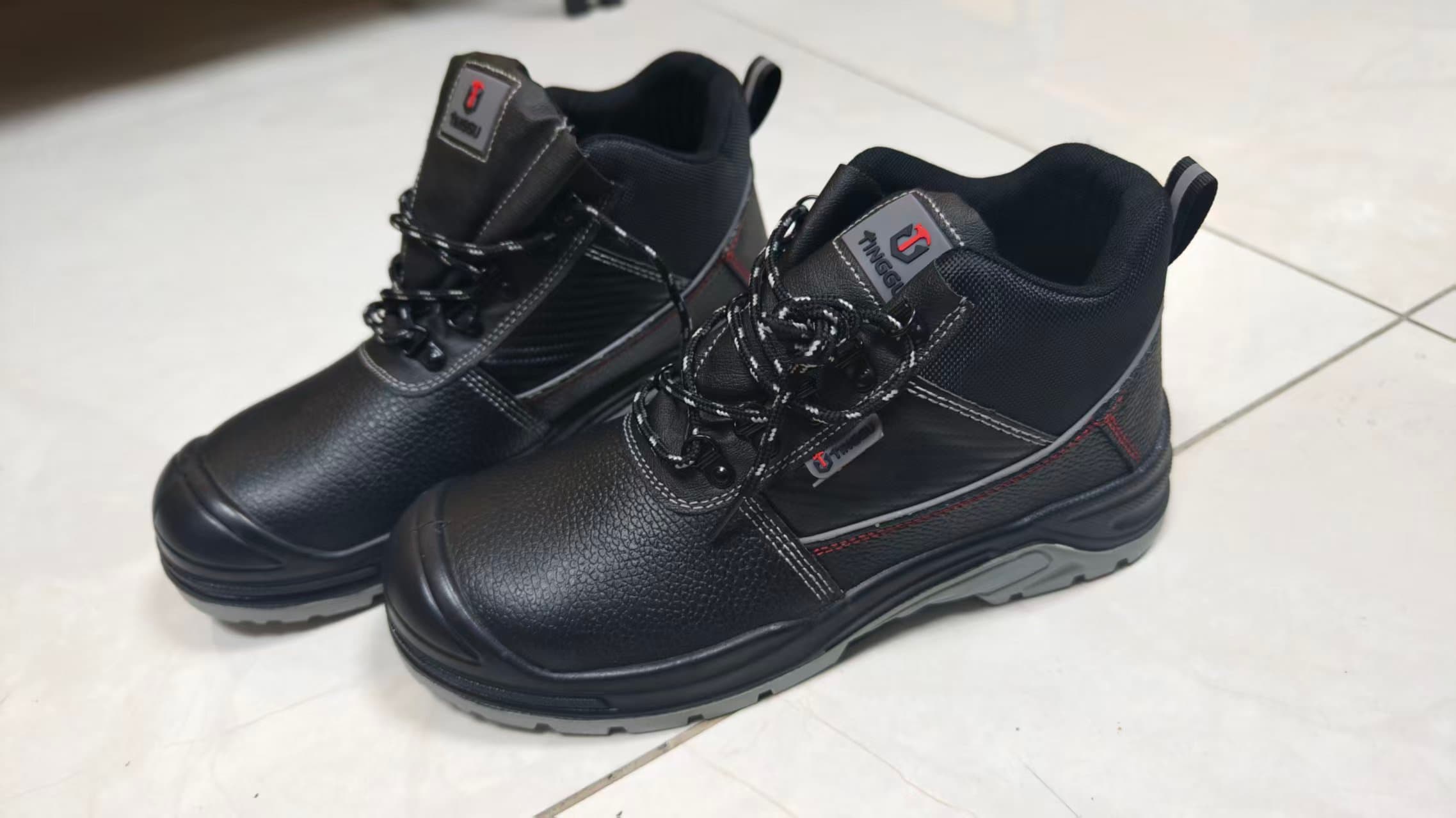 A pair of black lace-up footwear samples with contrasting soles.